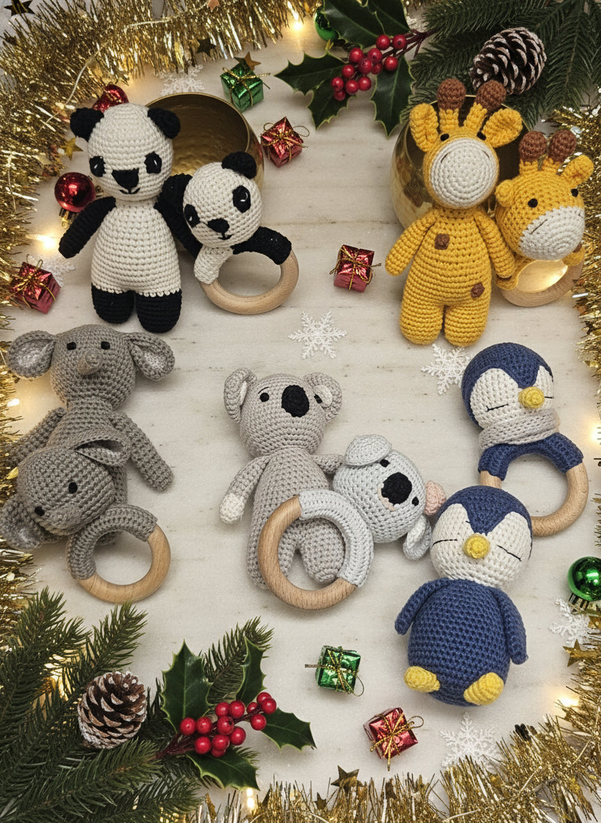 Collection of crochet toys including panda, lion, elephant, and penguin with wooden rings on a light wooden surface.