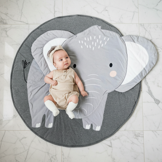Baby lying on a gray elephant-shaped play mat